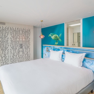 Drift into ocean dreams in your vibrant room with sea turtle artwork, tropical colors, and colorful pendant lighting.