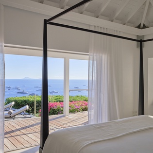Wake up to stunning sea views from your elegant four-poster bed, with French doors opening to your private terrace overlooking azure waters.