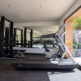 Your private fitness sanctuary awaits with state-of-the-art equipment and tropical garden views to energize your workout routine.