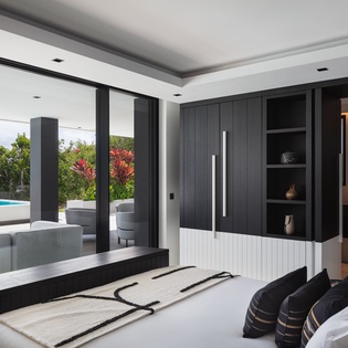 Unwind in your luxurious bedroom suite with stunning pool and garden views through floor-to-ceiling windows.