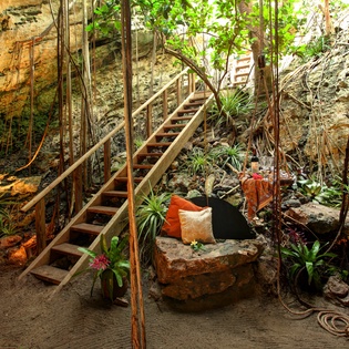You'll discover your own tropical sanctuary in this magical cenote-style seating area, where natural rock walls and lush greenery create pure tranquility.