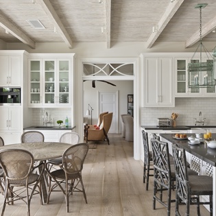 Gather around the elegant kitchen island or dine beneath soaring wood-beam ceilings in your bright, chef-ready space with classic white cabinetry and inviting breakfast nook.
