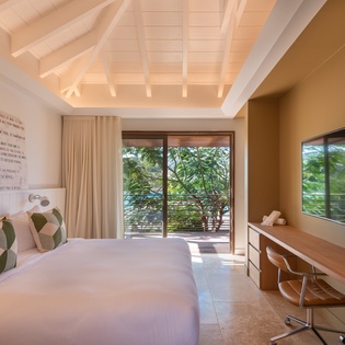 Unwind in your serene sanctuary with exposed beam ceilings, lush garden views, and modern comforts for the perfect tropical escape.