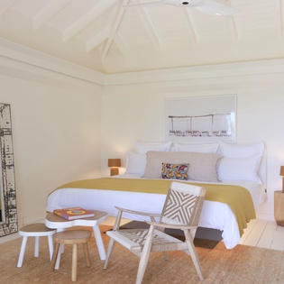 Unwind in your serene bedroom retreat, where soaring vaulted ceilings, crisp white linens, and warm wood accents create the perfect peaceful escape for your stay.