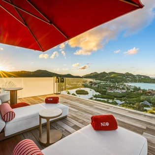 Sweeping views of tropical islands and azure waters from your private terrace with comfortable lounging and sunset umbrella shade.