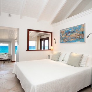 Your serene bedroom opens to stunning ocean views—drift off to the soothing sounds of the sea and wake to bright turquoise waters framed by your window.