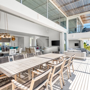 Your spacious outdoor dining terrace flows seamlessly into the modern interior, perfect for al fresco meals under dappled sunlight.