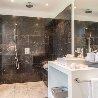 Indulge in your luxurious ensuite with rainfall showers, elegant marble accents, and pristine white towels awaiting your arrival.