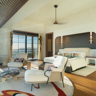 Your stunning suite combines comfort with ocean views, featuring a plush bed alcove and stylish seating area where you'll unwind.