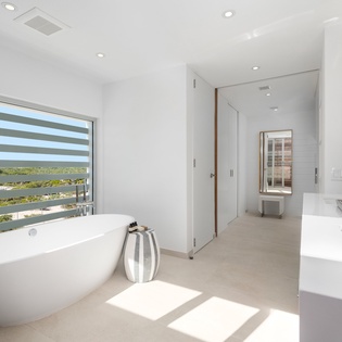 Unwind in your spa-like bathroom featuring a luxurious soaking tub with natural light and sleek modern fixtures for ultimate relaxation.
