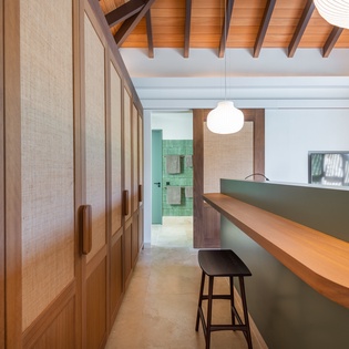 Your modern kitchen features warm wood accents against soothing sage cabinetry, creating an inviting space to prepare meals under beautiful exposed beams.