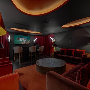 Sink into plush velvet seating in your private cinema lounge, where dramatic lighting and rich textures create the perfect atmosphere for movie nights.
