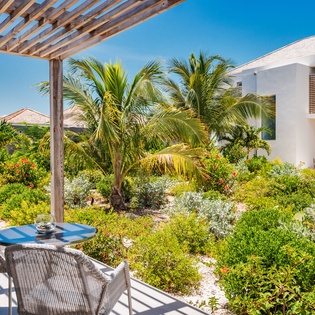 Sip your morning coffee while gazing at lush tropical gardens framed by swaying palms and vibrant blooms from your private terrace.
