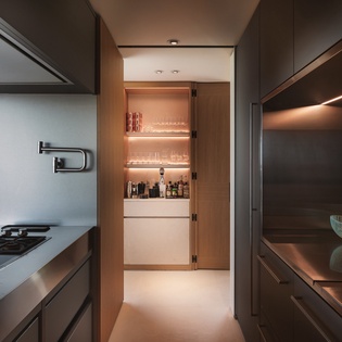 Your sleek galley kitchen combines modern design with ocean views, featuring premium appliances and warm lighting for effortless cooking.
