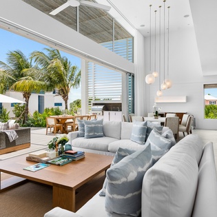 Sink into plush sofas while tropical breezes flow through floor-to-ceiling windows, blending indoor luxury with paradise views.