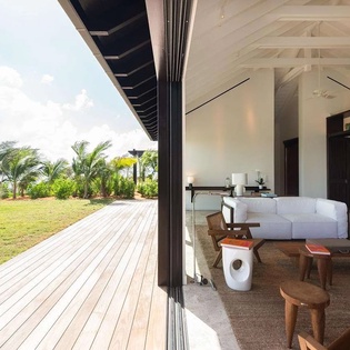 Relax in your spacious living room where elegant design meets breathtaking sea and sky views. Step onto the wooden deck to enjoy tropical breezes and lush lawn.