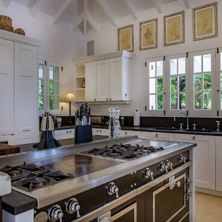 Step into your gourmet kitchen where restaurant-grade appliances meet elegant island workspace. Tropical breezes drift through the shuttered windows while you prepare memorable meals in this chef-inspired space.