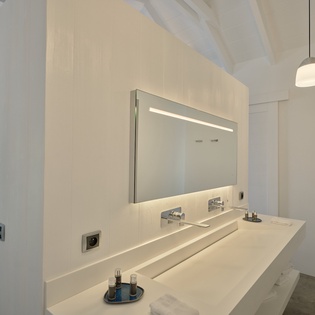 Enjoy your morning routine in this sleek bathroom with stunning sea views through the window.
