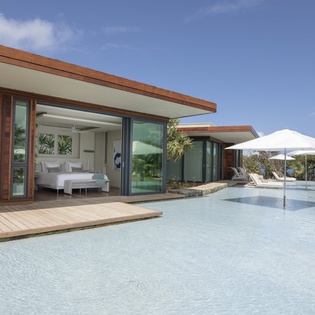 Step into your modern sanctuary where floor-to-ceiling windows blur the line between your luxurious bedroom and pristine pool paradise.