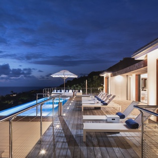 Luxury poolside terrace at twilight offers stunning ocean views, modern elegance, and serene ambiance for your perfect evening retreat.