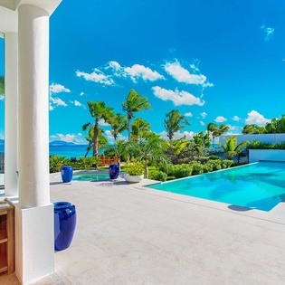 Your private tropical escape features a pristine infinity pool, lush palm trees, and turquoise ocean views. Plush towels await as you lounge poolside or relax under the covered patio.