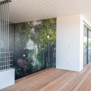 Relax on your private terrace with warm wood decking, modern artistic touches, and peaceful outdoor seating perfect for morning coffee or evening unwinding.