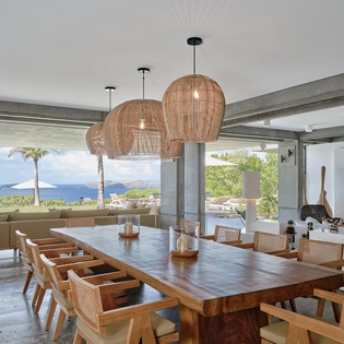 Your spacious dining area flows seamlessly to stunning ocean views, where natural materials and island-inspired design create the perfect setting for memorable meals.