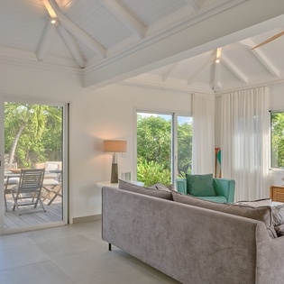 Relax in your bright living space with soaring vaulted ceilings and large windows that frame lush tropical views.