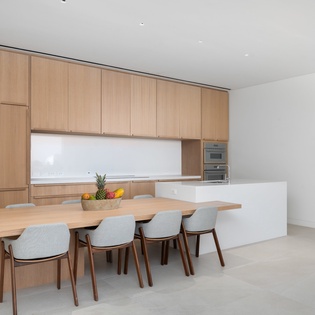 Your sleek kitchen features warm wood cabinetry and a spacious island perfect for morning coffee or evening meals with loved ones.