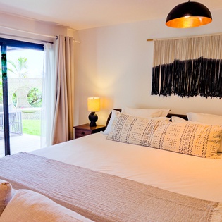 Drift off in this bright, stylish bedroom where crisp linens meet warm textures. Wake to garden views from your private terrace, perfect for morning coffee in the fresh air.