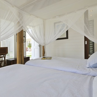 Drift into peaceful slumber under romantic netting in your bright, airy bedroom sanctuary.