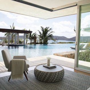 Relax in your stunning living space with floor-to-ceiling windows opening to an infinity pool and breathtaking ocean views.