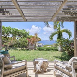 Step onto your private terrace and soak in breathtaking ocean views. Lush tropical gardens and breezy palms frame your peaceful outdoor lounge, where you can relax under the shaded pergola and watch the waves roll in.