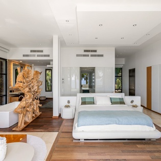 Unwind in your stunning master suite with modern design, soaring ceilings, and serene garden views through floor-to-ceiling windows.