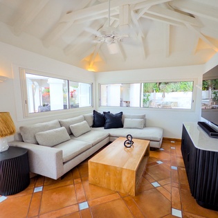 Unwind in your bright living room with vaulted ceilings, plush seating, and garden views through large windows. The space invites you to relax after exploring the area.