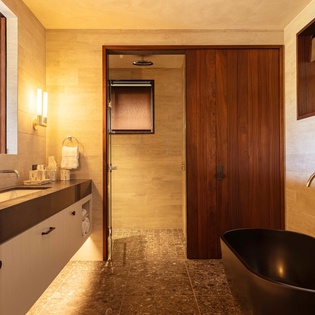 Step into your luxurious bathroom sanctuary with sleek black soaking tub, rain shower, and warm wood accents creating the perfect spa-like retreat.