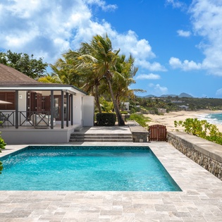 Private beachfront oasis awaits, where your sparkling pool meets golden sand and endless turquoise waters, framed by swaying palms and tropical breezes under Caribbean skies.
