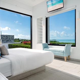 Wake up to stunning turquoise waters framed by floor-to-ceiling windows. Your serene escape features crisp linens, modern comfort, and unobstructed ocean views that bring the beach right to your bedside.