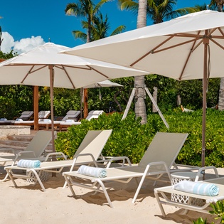 Sink into your private beach lounger under swaying palms, where soft sand meets turquoise waters and every detail invites you to unwind in tropical paradise.
