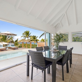 Your private dining space opens to tropical paradise views, where your pool meets ocean breezes and swaying palms.