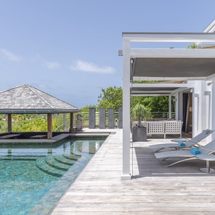 Bask in the sunshine on your private poolside deck, where sleek loungers and a shaded gazebo invite you to unwind in pure tropical luxury.