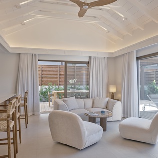 Unwind in your elegant living space featuring plush seating, designer ceiling, and seamless access to your private outdoor terrace.