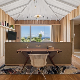 Your private workspace features warm wood tones and ocean glimpses, creating the perfect blend of productivity and paradise views.