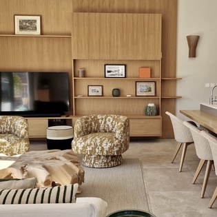 Unwind in your modern living space with custom wood shelving, cozy velvet seating, and a sleek kitchenette perfect for preparing light meals.