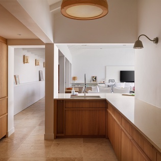Step into your sleek, open-concept kitchen with warm wood cabinetry and modern appliances, where meal prep flows effortlessly into relaxation in the adjoining living space.
