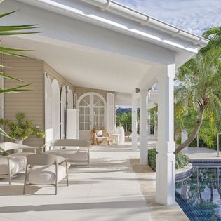 Relax on your private covered terrace with elegant white furniture, overlooking your pool surrounded by lush tropical gardens.