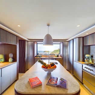Cook with stunning ocean views in this beautifully designed kitchen, where modern appliances and warm wood details create your perfect culinary retreat.
