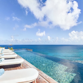 Stunning infinity pool deck with pristine ocean views and comfortable loungers for ultimate relaxation.