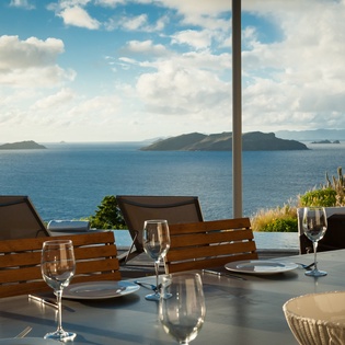 Sip wine at your private terrace table while soaking in breathtaking ocean views and island horizons stretching endlessly before you.