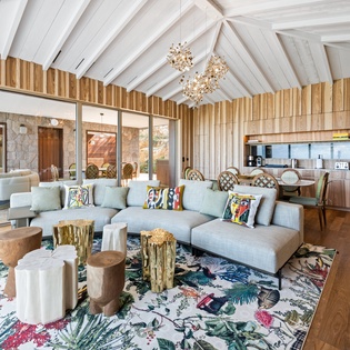 Relax in this stunning open-concept living space where soaring vaulted ceilings meet modern luxury and vibrant artistic touches.